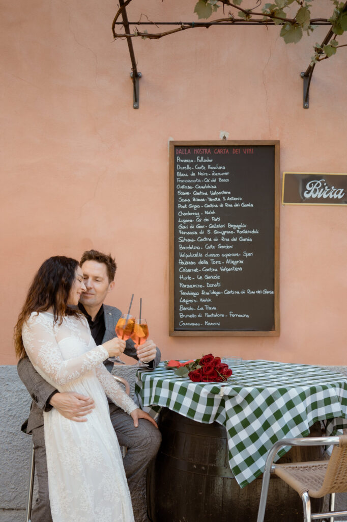 Couple sharing spritz during their Malcesine elopement on Lake Garda