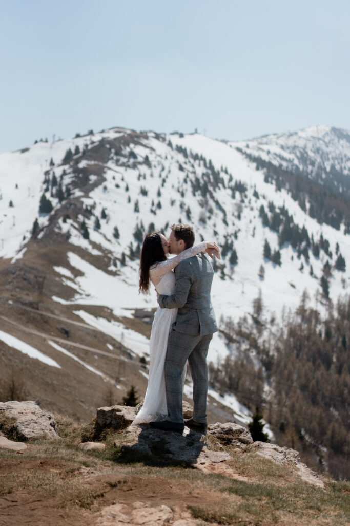 Couple kissing on Monte Baldo during their Malcesine elopement above Lake Garda