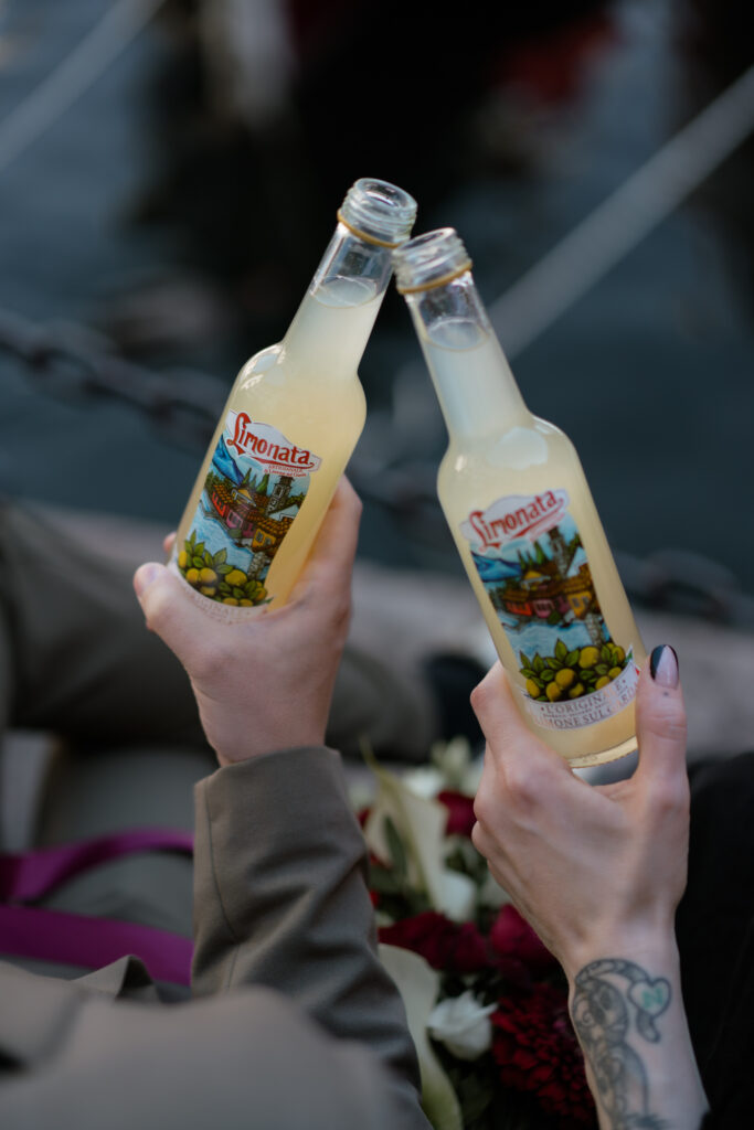 Couple toasting with limonata during their Limone del Garda elopement on Lake Garda