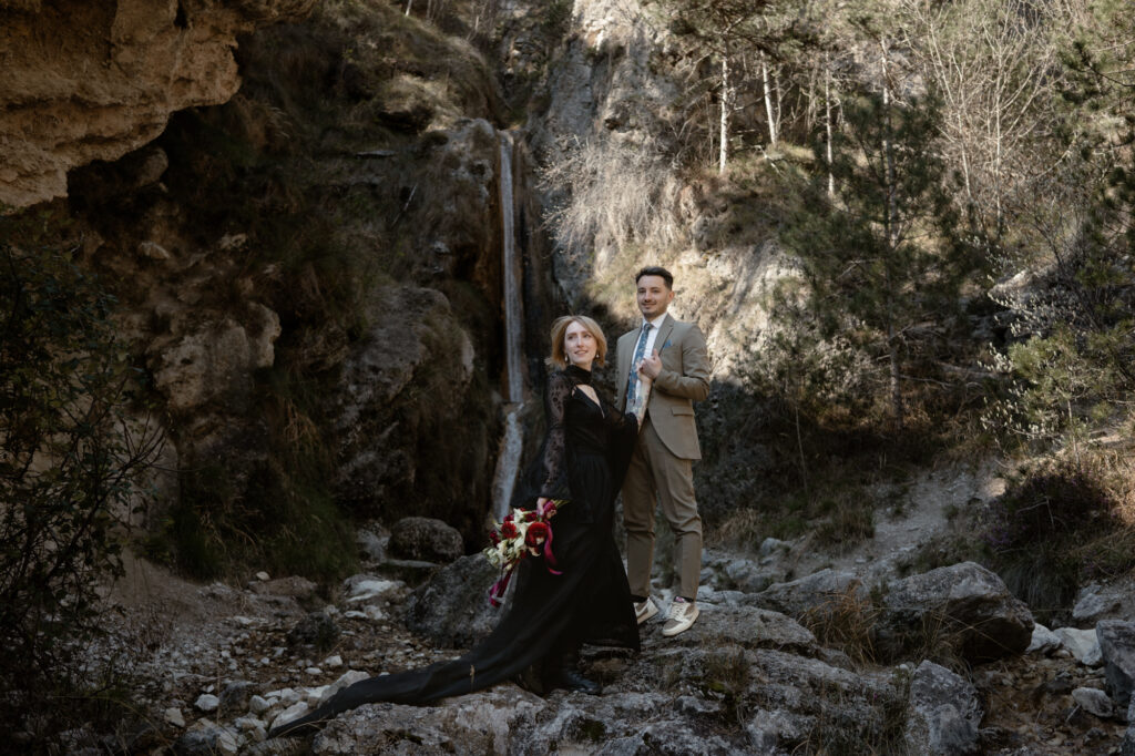 Couple posing near a waterfall during their Limone del Garda elopement in Northern Italy