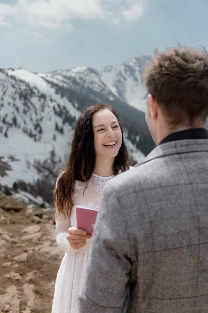 Bride laughing while reading vows during a Malcesine elopement on Monte Baldo