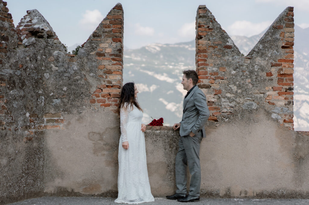 Couple standing by the castle walls during their Malcesine elopement on Lake Garda