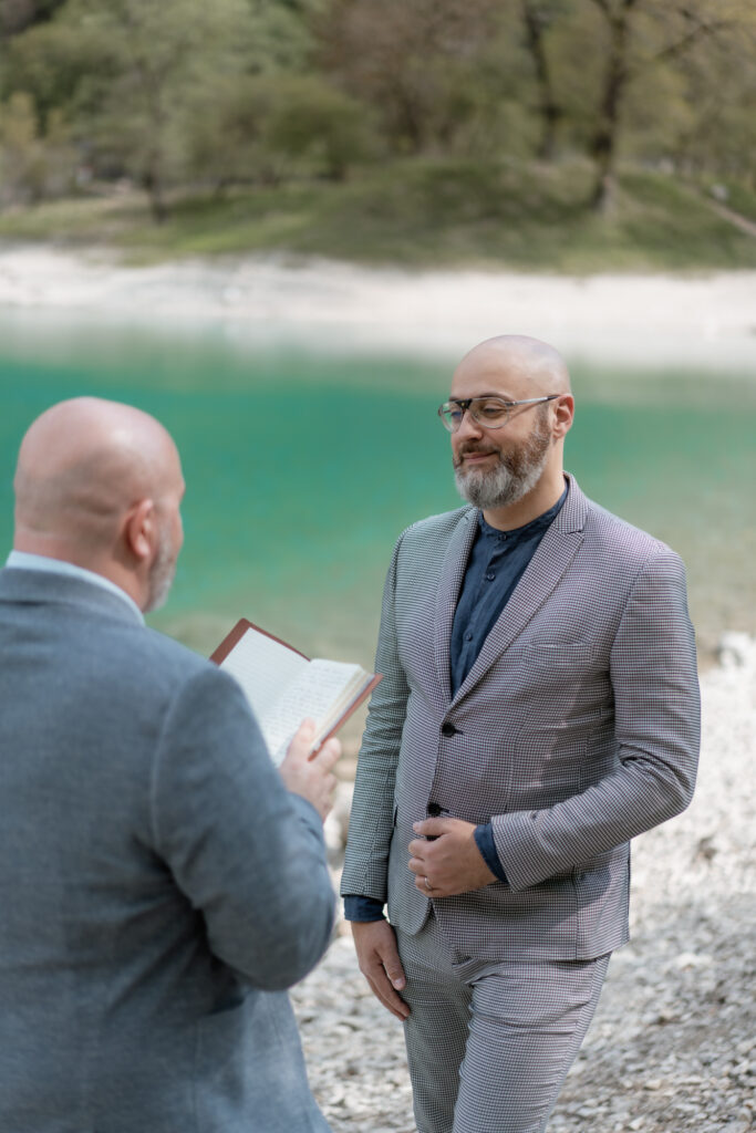 LGBTQ+ couple exchanging vows by Lake Tenno during their Italy elopement