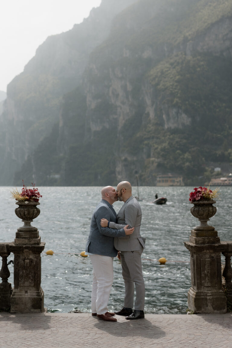 LGBTQ+ couple kissing by the water during their Lake Garda elopement in Riva del Garda