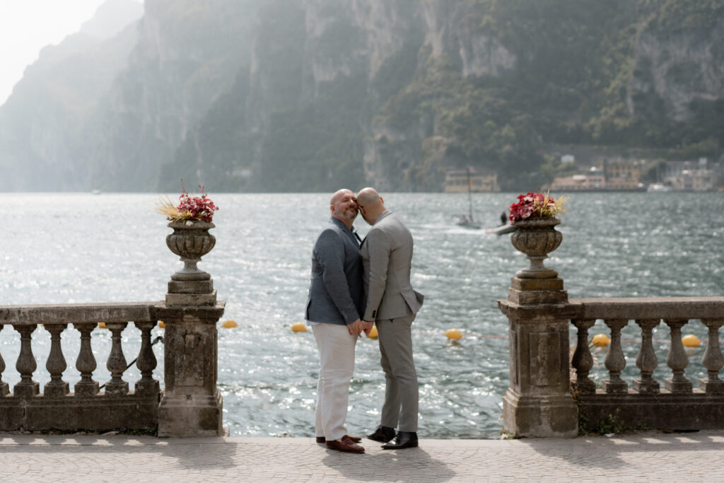 LGBTQ+ couple standing together by Lake Garda during their Riva del Garda elopement