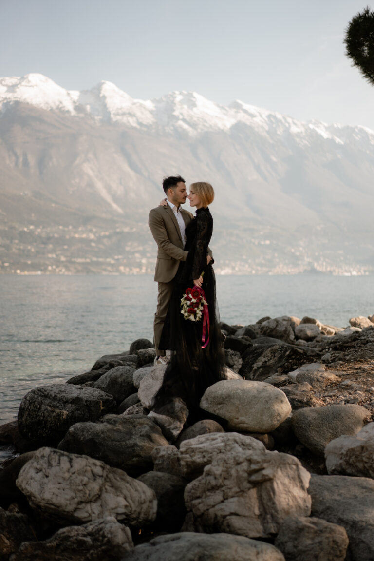 Couple standing on rocks by Lake Garda during their Limone del Garda elopement