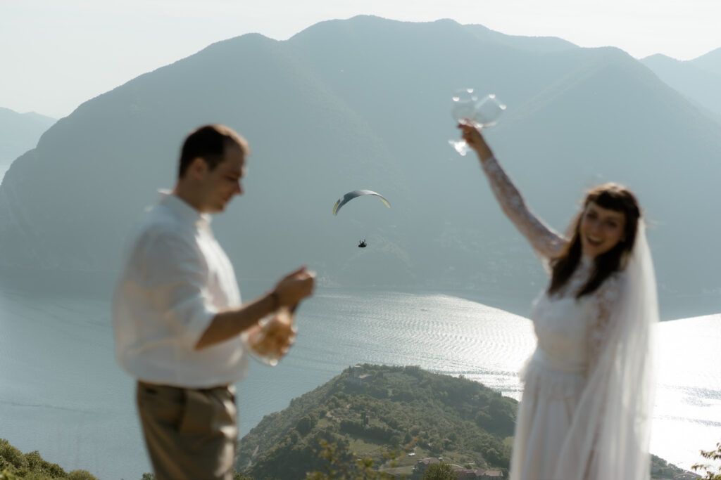 Couple celebrating with champagne above Lake Iseo during their Monte Isola elopement