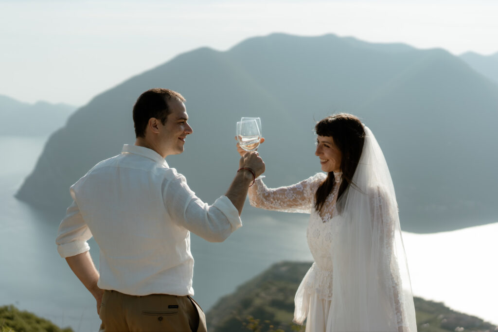 Couple toasting with wine above Lake Iseo during their Monte Isola elopement in Italy
