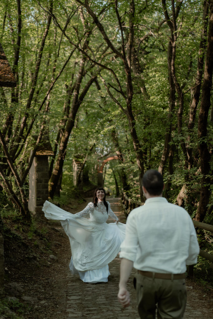 Bride walking toward the groom on a woodland path during their Monte Isola elopement in Italy