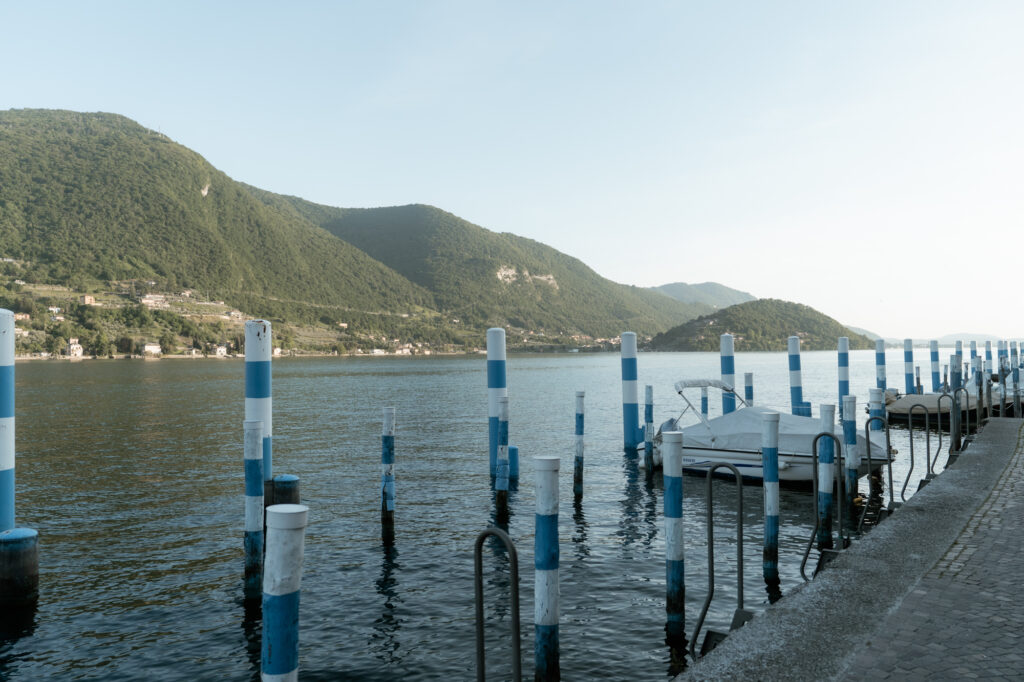 Harbour and blue mooring poles on Monte Isola during a Lake Iseo elopement day