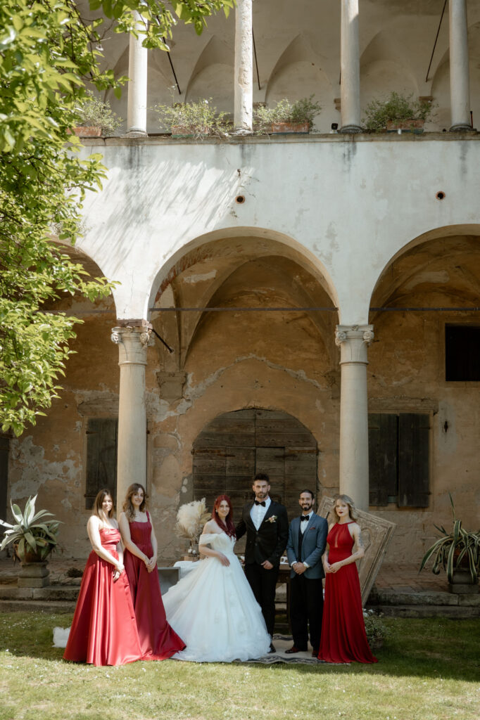 Bride, groom, and close wedding party standing together at a countryside villa in Italy