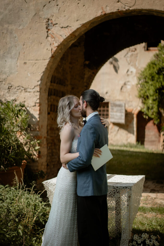Couple kissing during their intimate wedding ceremony at a countryside villa in Italy