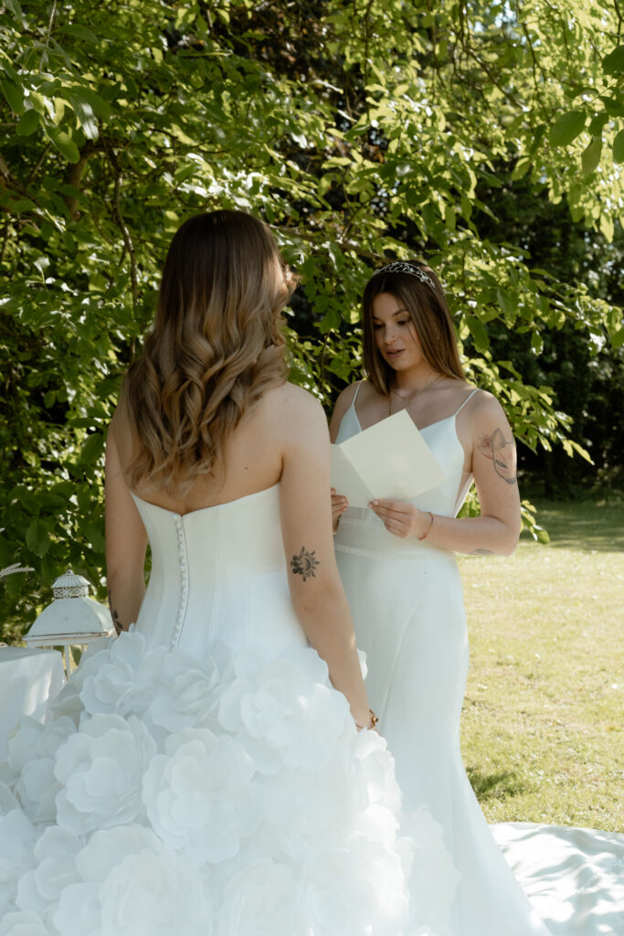 LGBTQ+ couple reading vows during an intimate wedding at a countryside villa in Italy