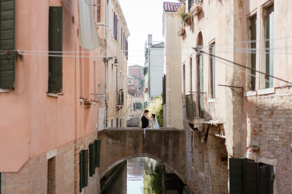 Couple standing on a bridge over a canal during their Venice elopement in Italy