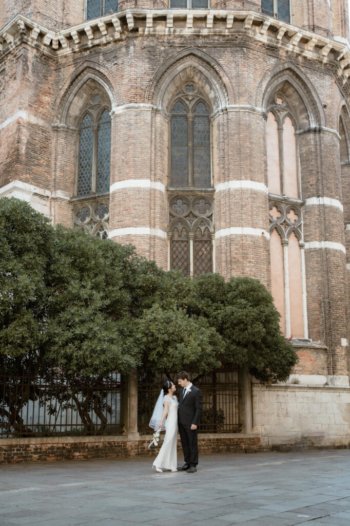 Couple standing near a historic church during their Venice elopement portraits