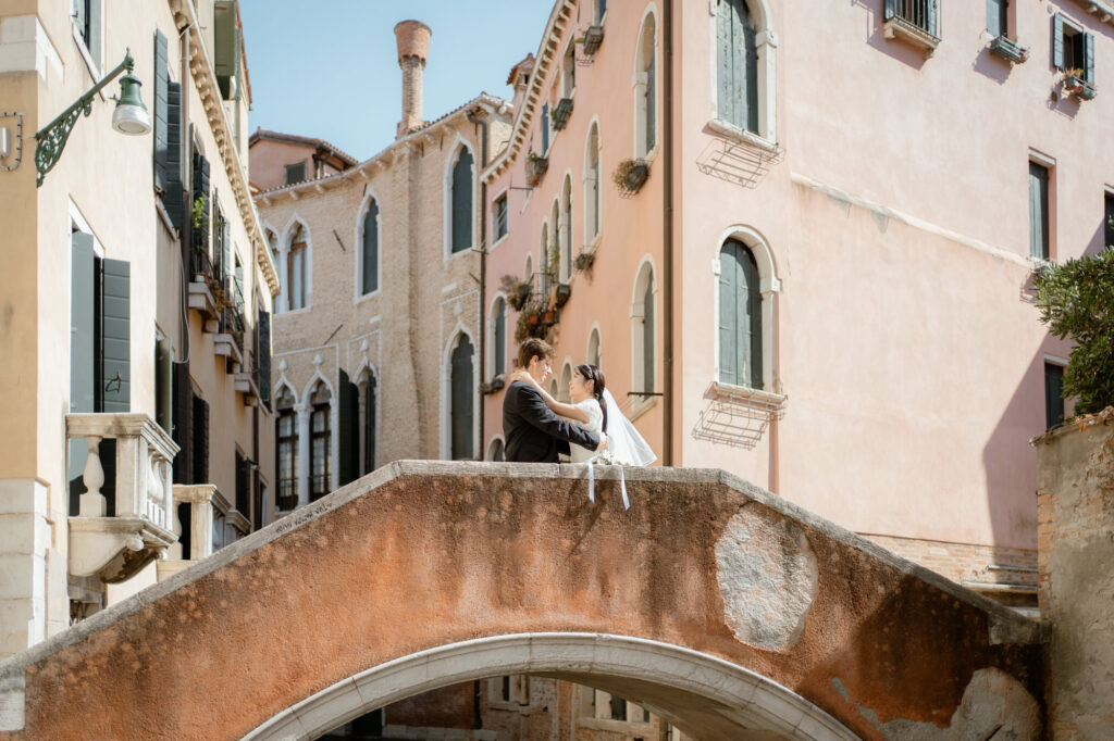 Couple sitting together on a bridge during their Venice elopement in Italy