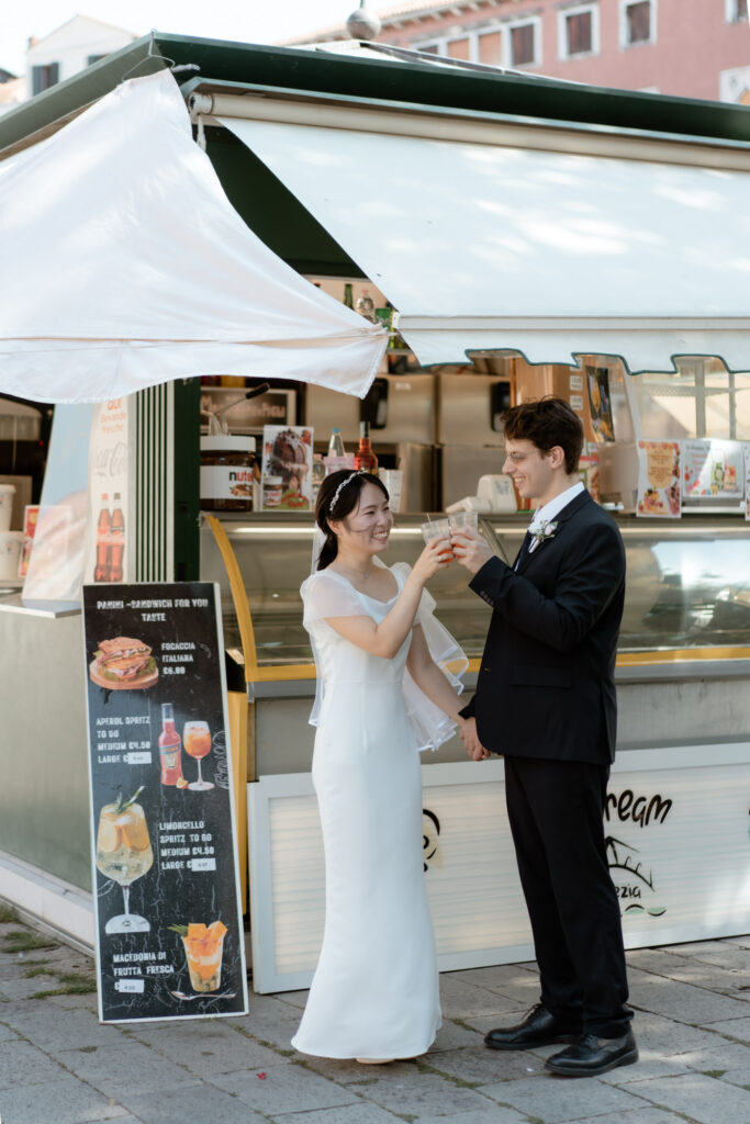 Couple toasting with drinks during their Venice elopement in Italy