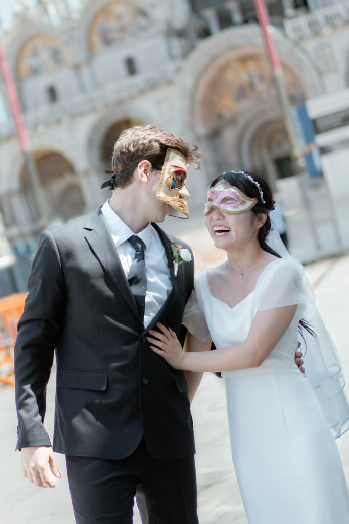 Couple wearing Venetian masks during their elopement portraits in Venice