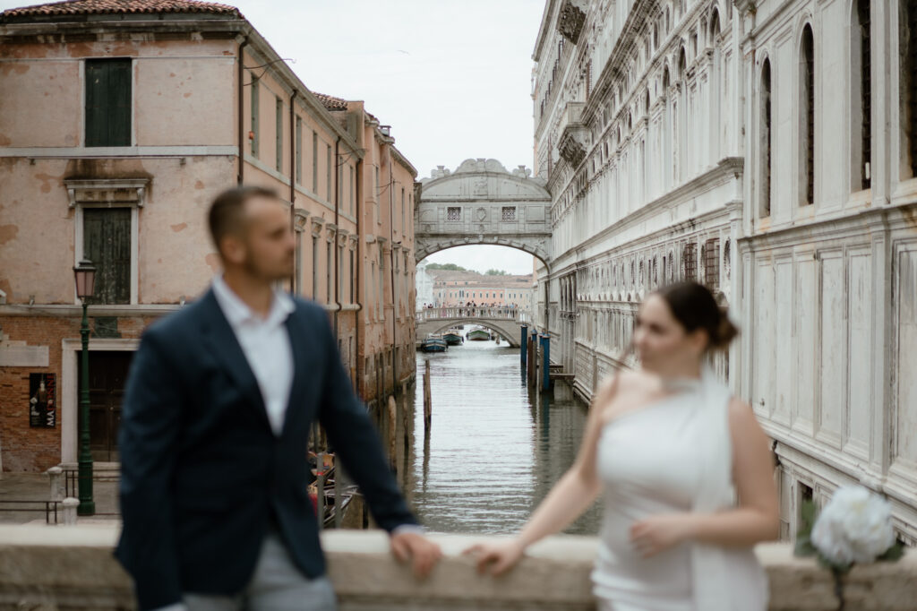 Couple holding hands near the Bridge of Sighs during their Venice elopement in Italy
