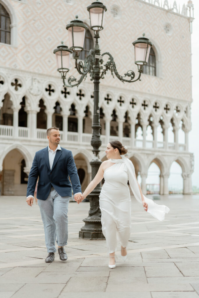 Couple walking hand in hand in Piazza San Marco during their Venice elopement in Italy