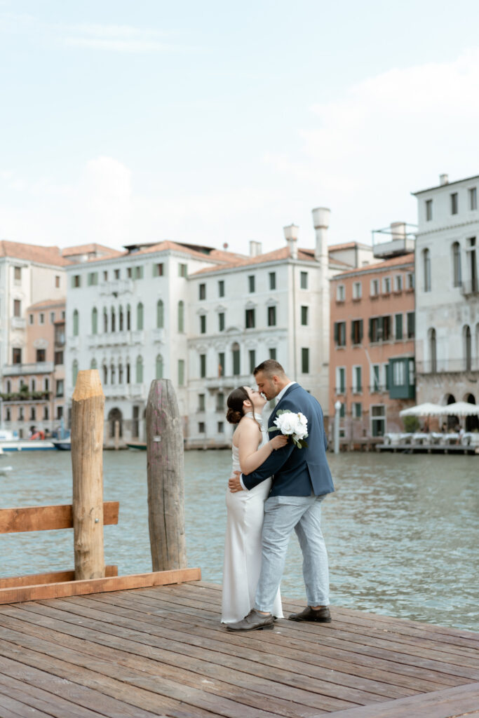 Couple kissing on a dock by the Grand Canal during their Venice elopement in Italy