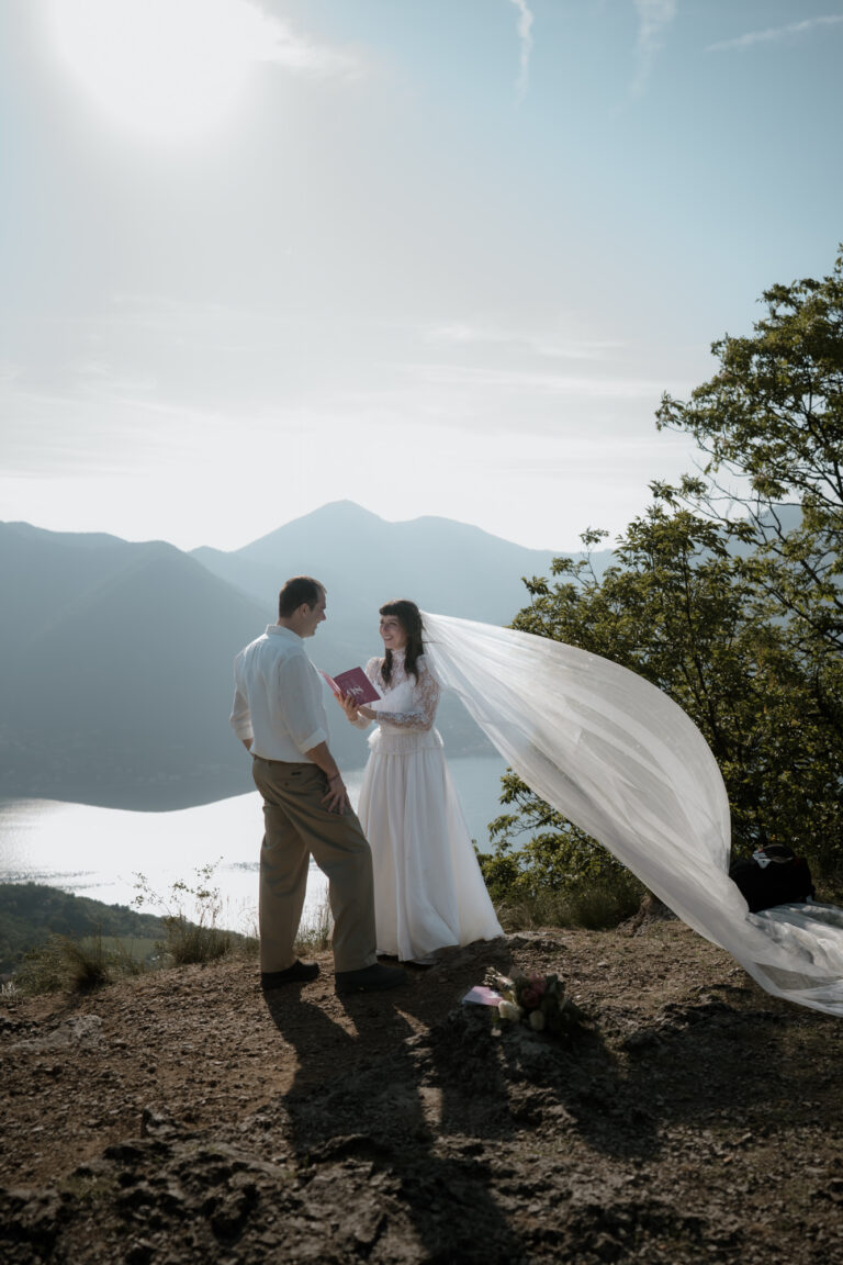 Couple exchanging vows on Monte Isola with Lake Iseo and mountains behind them