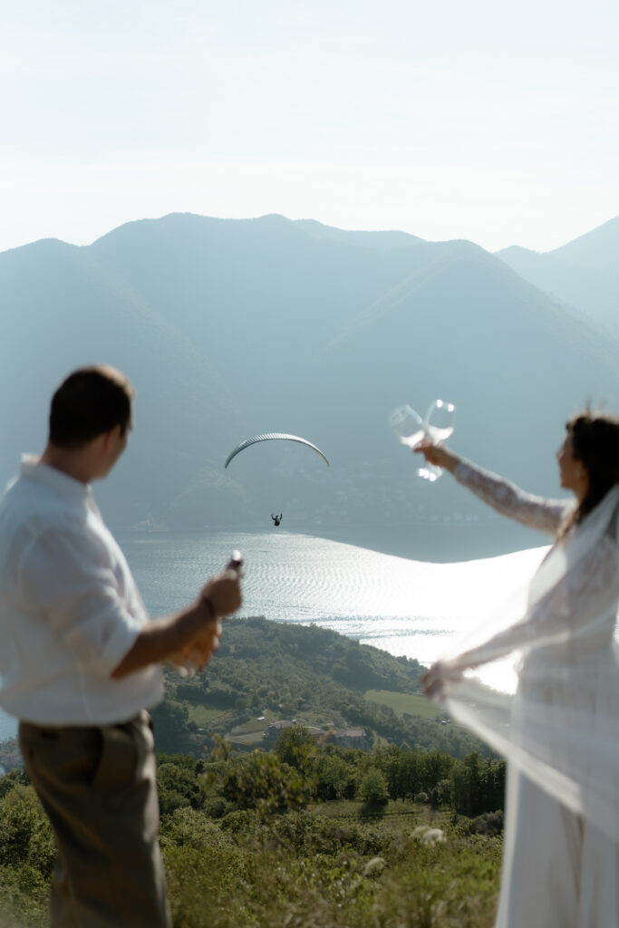 Couple celebrating with champagne during their Monte Isola elopement overlooking Lake Iseo