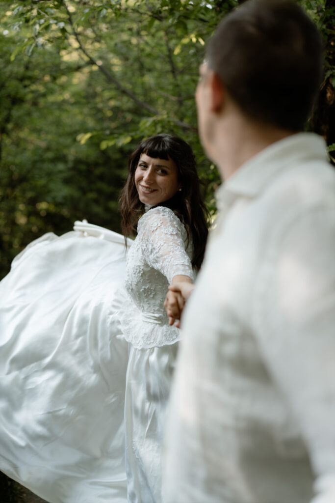 Bride holding the groom’s hand during their Monte Isola elopement on Lake Iseo in Italy