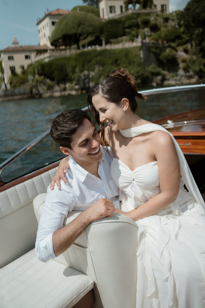 Couple laughing together on a classic boat near Varenna during a Lake Como elopement session